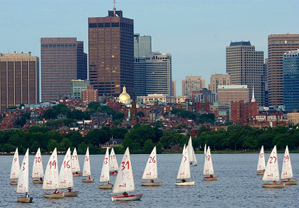 Photograph of sailboats on the Charles River with the Boston skyline in the background.