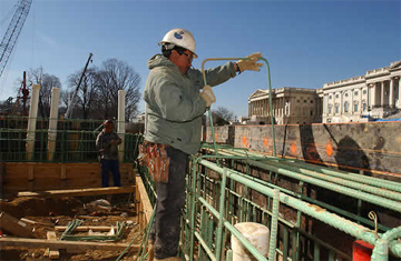 Worker secures steel to the top of perimeter wall.