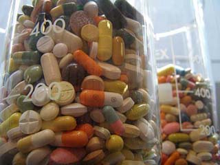 Two large beakers hold hundreds of pills in all shapes, sizes, and colors.
