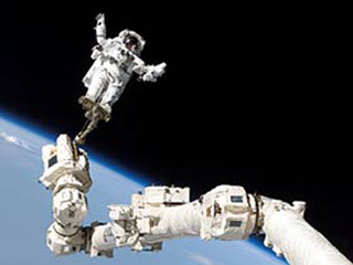 Astronaut in space, standing on a long robotic arm. Astronaut in space, standing on a long robotic arm.