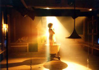 A photo of a performer bathed in a bright yellow light.