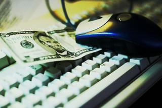 Photograph of a five dollar bill on a computer keyboard. Photograph of a five dollar bill on a computer keyboard.